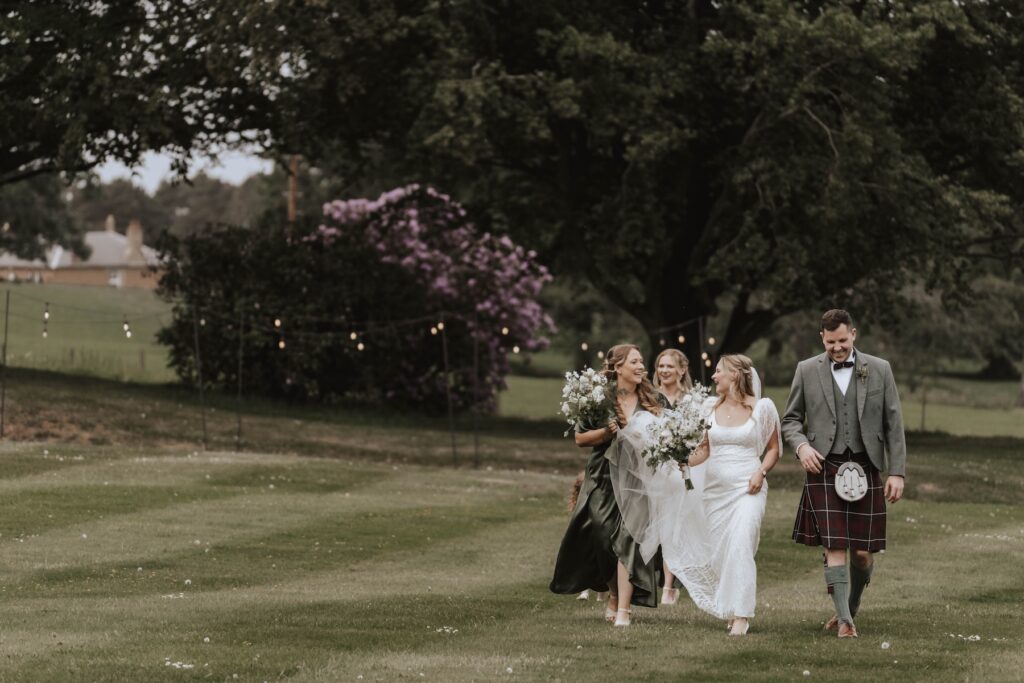 Bride walking to church ruins at Dunglass Estate