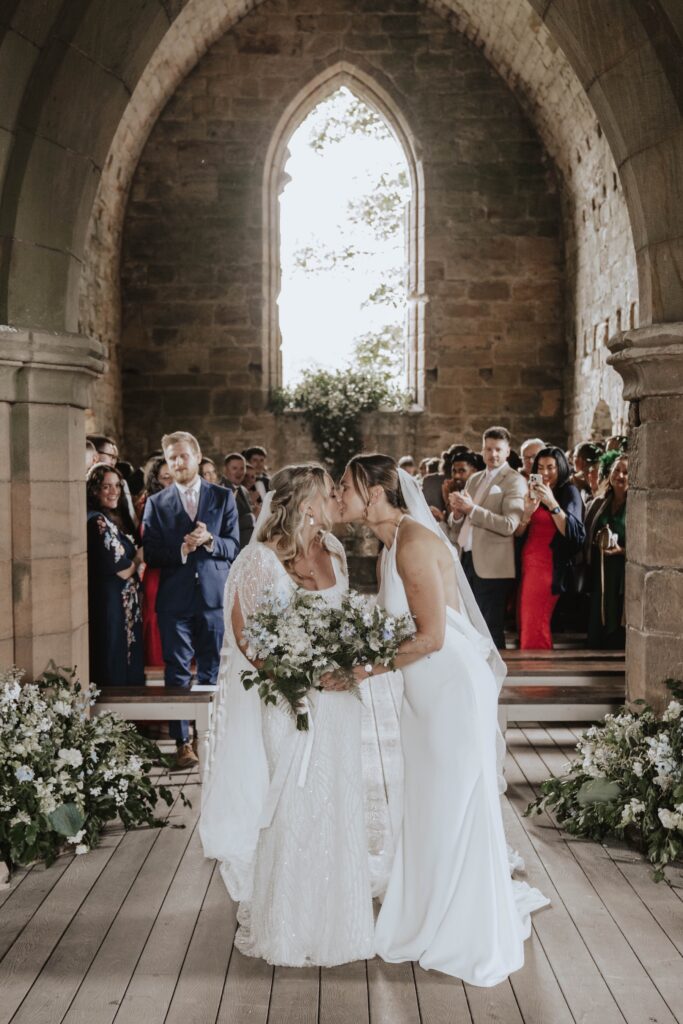 Two brides walking back down the aisle at Dunglass Estate