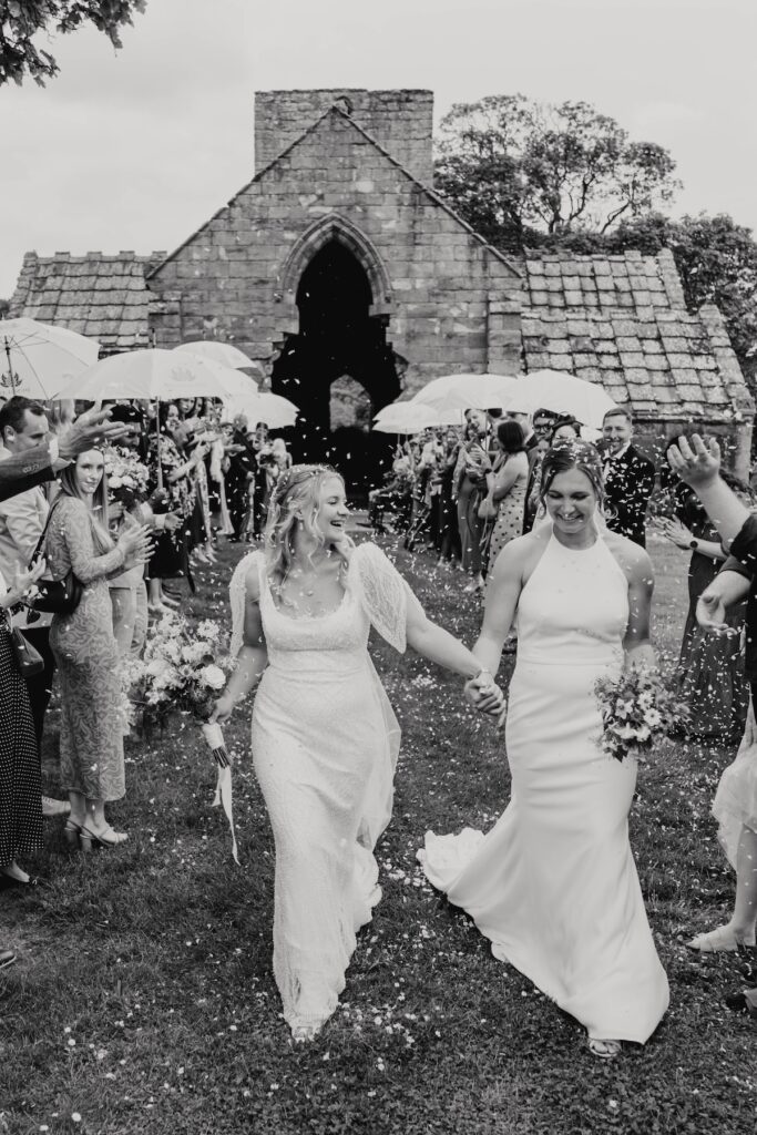 Couple walking during confetti at Dunglass Estate