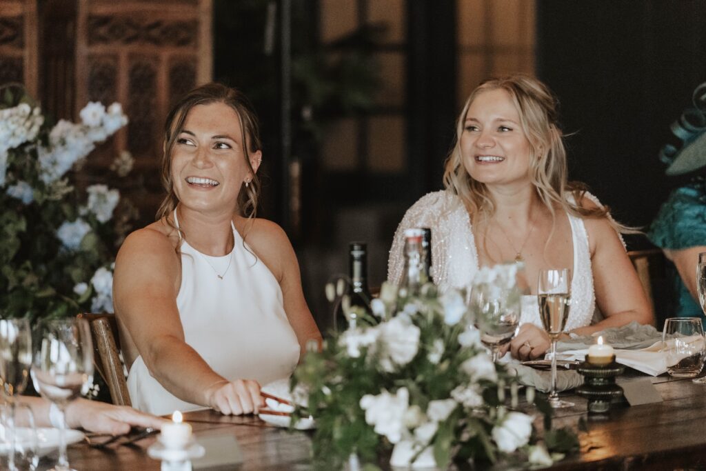 Brides laughing during wedding speeches