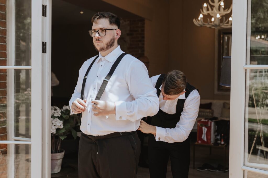 Groom Josh getting ready with his groomsmen before his Gaynes Park wedding
