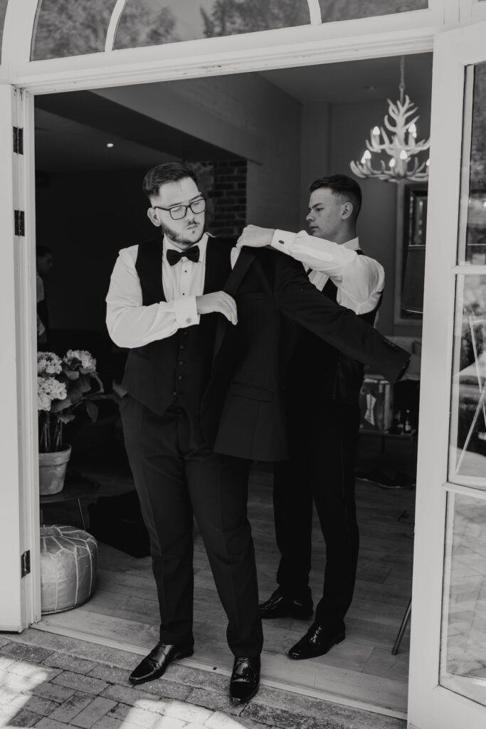 Josh wearing a classic black tie suit on his wedding morning in Essex