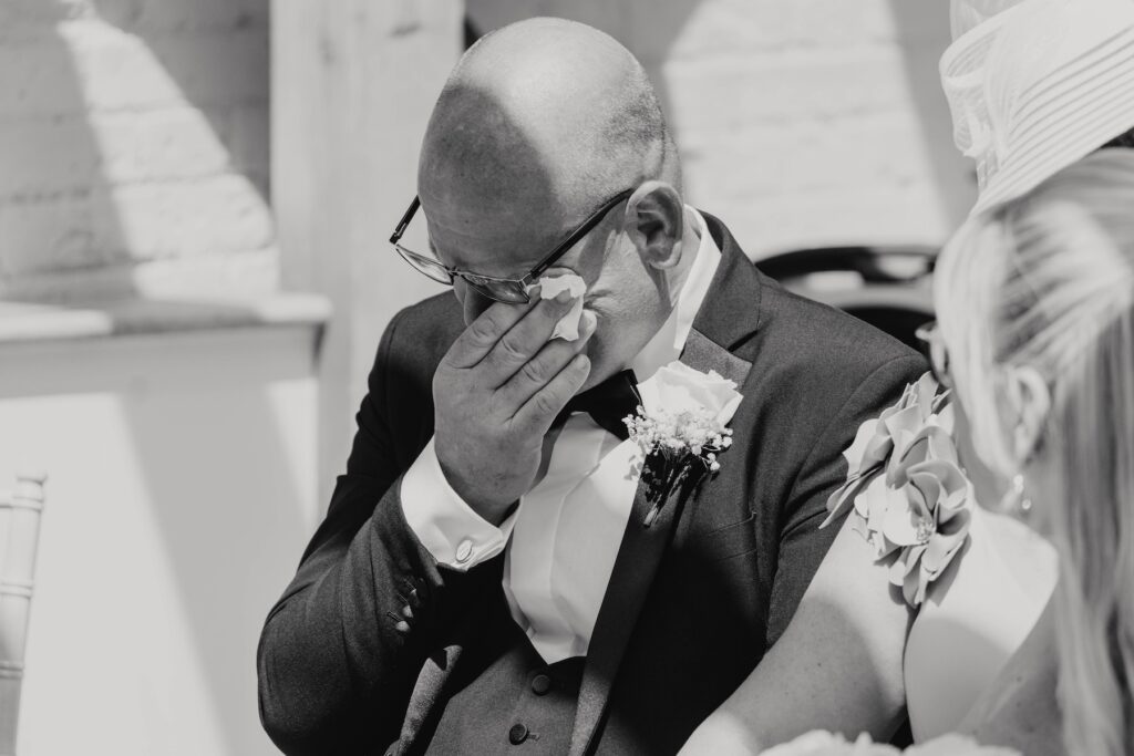 Emotional wedding guests watching Abbie walk down the aisle