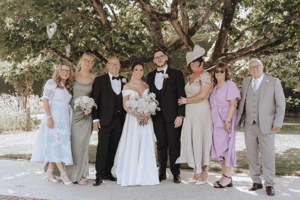 Family wedding photograph in the gardens at Gaynes Park