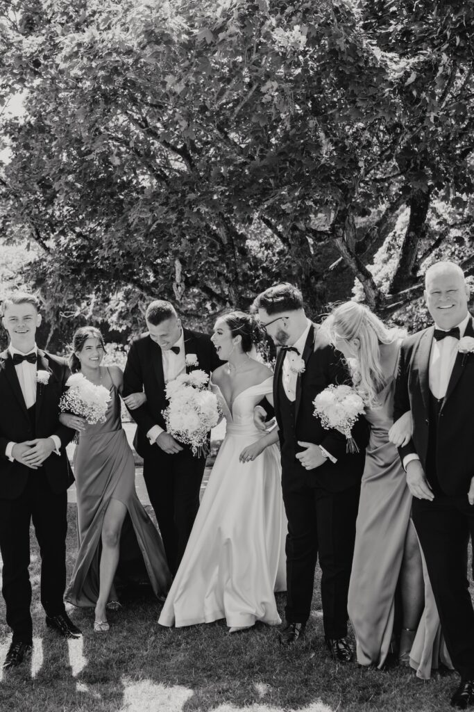 Bride and groom with their groomsmen during their summer wedding
