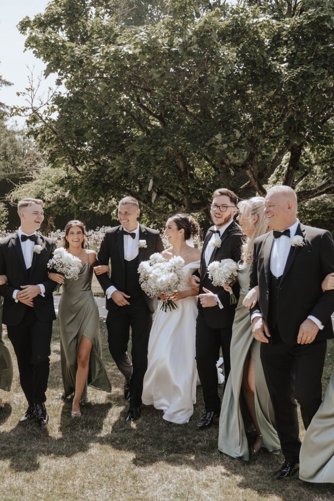 Wedding party photograph beneath a tree at Gaynes Park