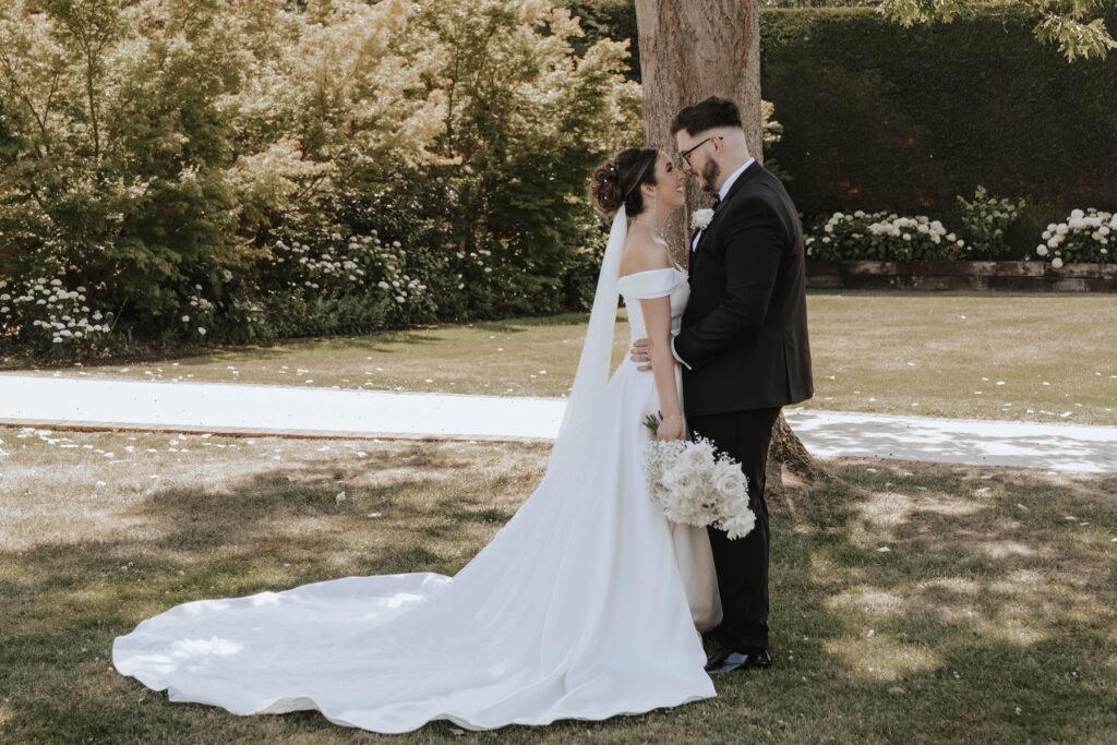 Newlyweds walking together through the gardens at Gaynes Park