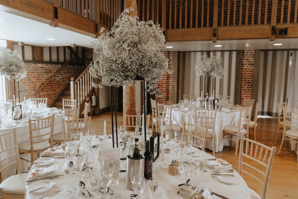 Elegant wedding reception tables decorated with white roses and greenery