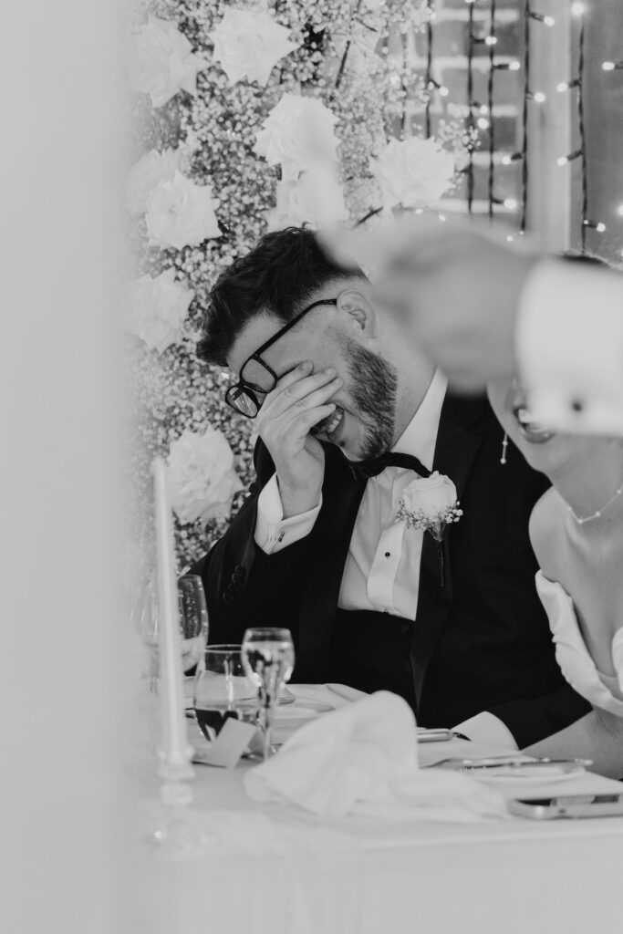 Groom Josh listening to the wedding speeches at Gaynes Park