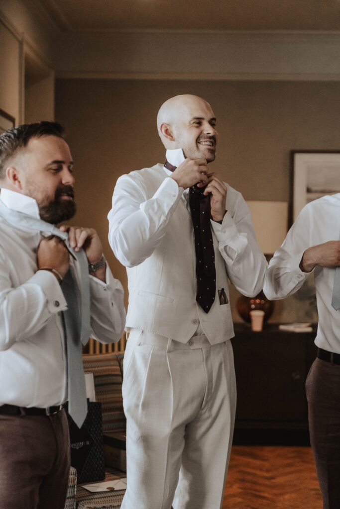 Groom James getting ready with his groomsmen at Cornwallis House in Hadleigh