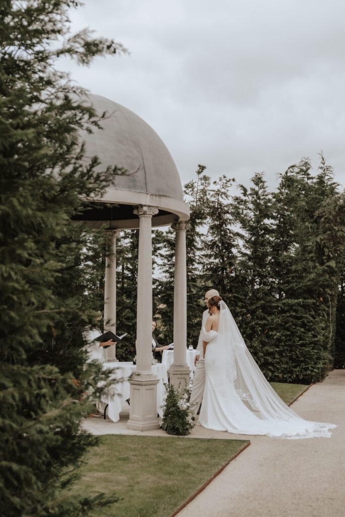 Bride and groom exchanging vows in the gardens at Marquis Suffolk