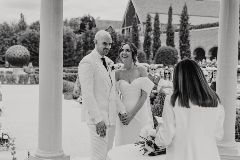 Bride and groom smiling during their outdoor wedding ceremony