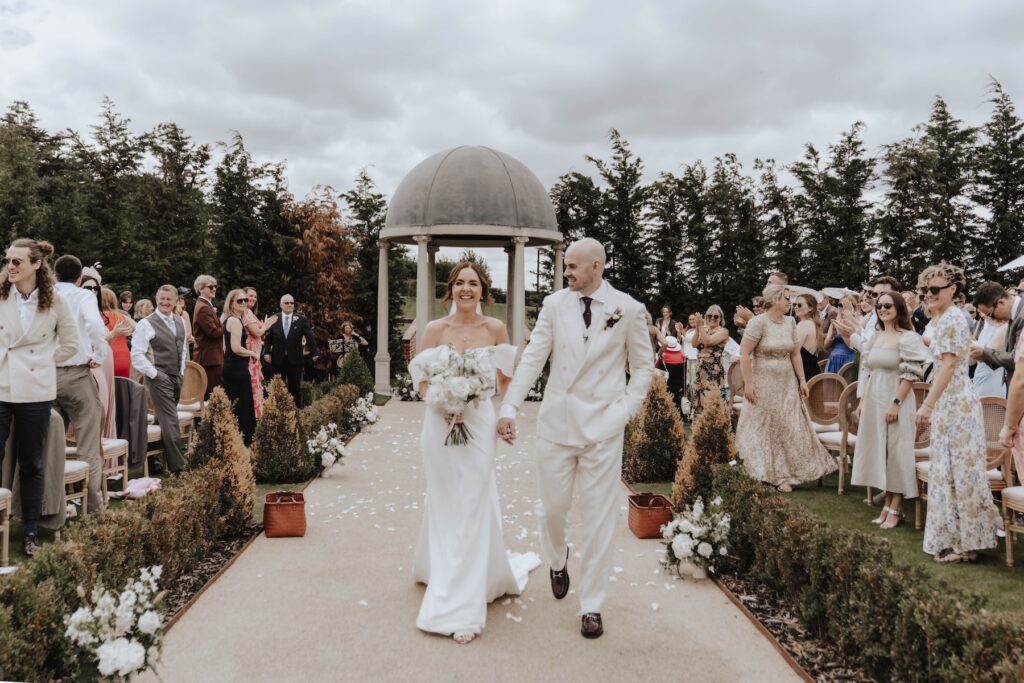 Couple walking down aisle at Marquis Italian gardens
