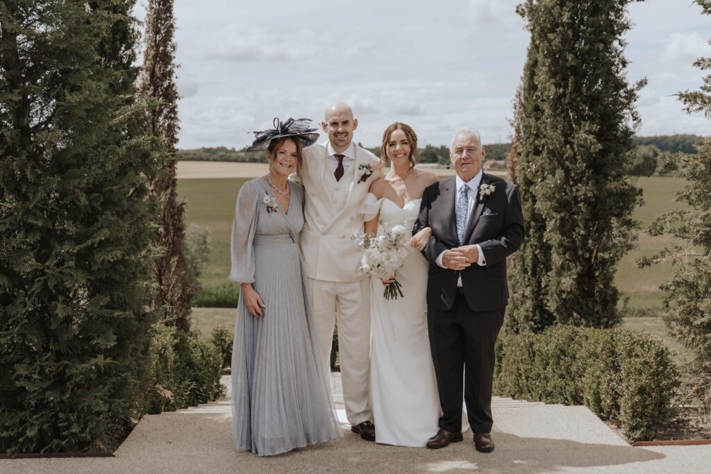 Lauren and James with their family during their Marquis Suffolk wedding