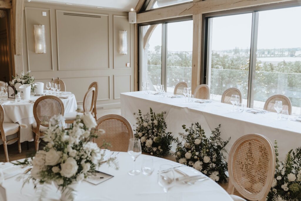 Cream and green wedding flowers decorating the wedding breakfast room