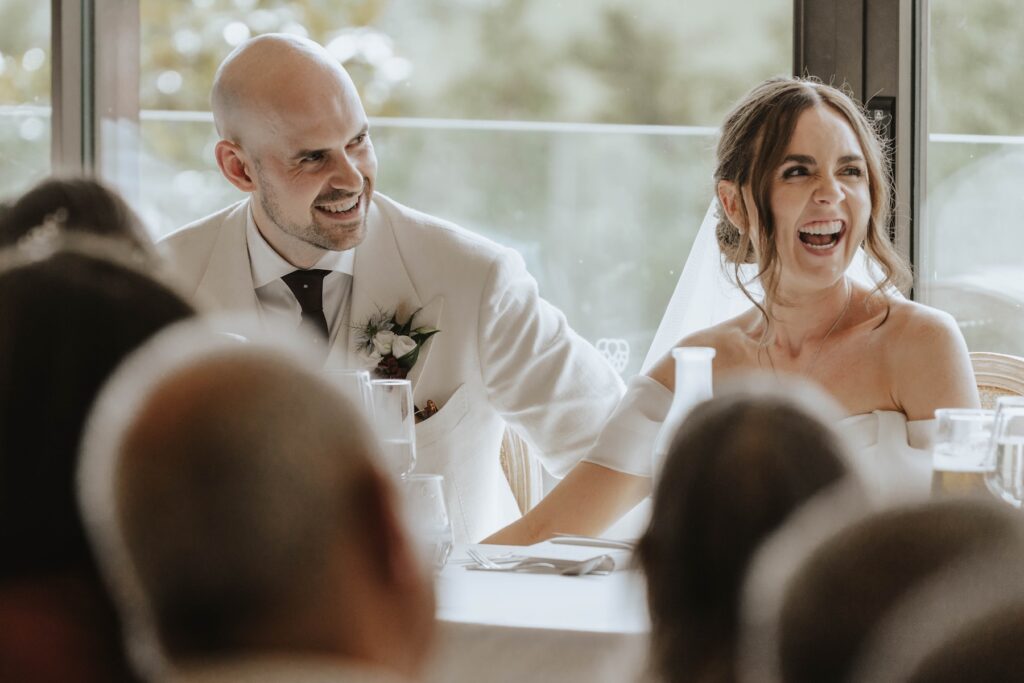 Bride and groom listening to speeches during their Marquis Suffolk wedding