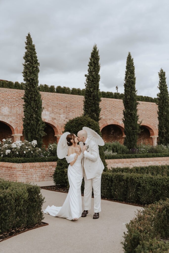 Newlyweds with parasols during their evening wedding portraits