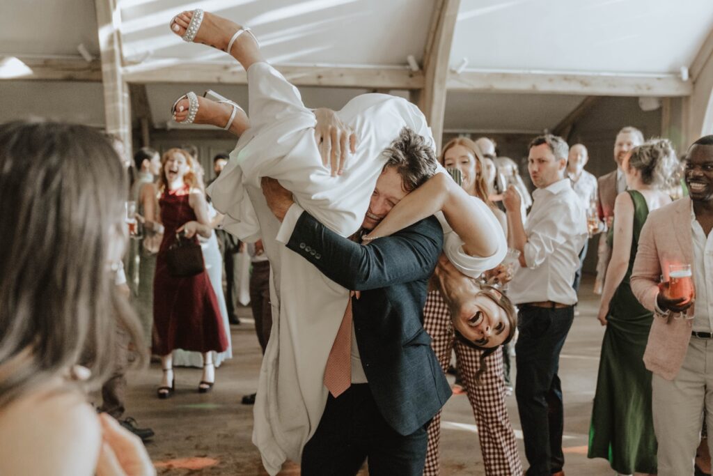 Bride Lauren being lifted up while dancing at her wedding reception
