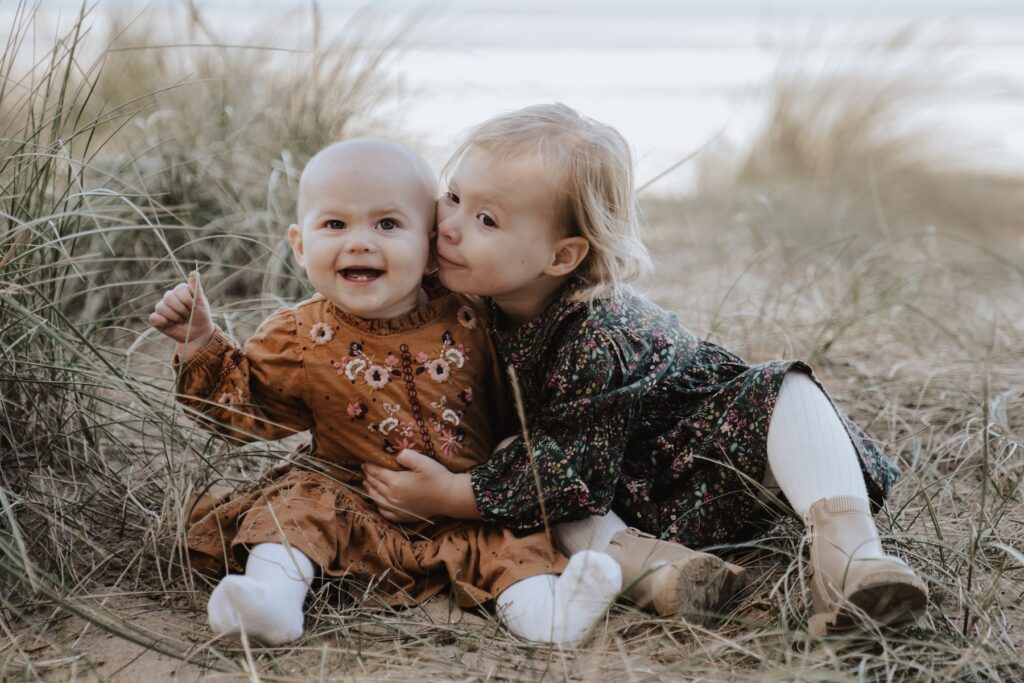 Two sisters exploring the woodland at Holkham Beach in Norfolk