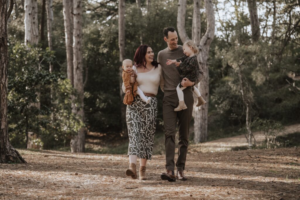 Parents cuddling their daughters during a relaxed family photography session