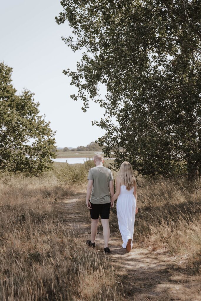 Shannon and Dom walking together during their engagement session at Snape Maltings in Suffolk