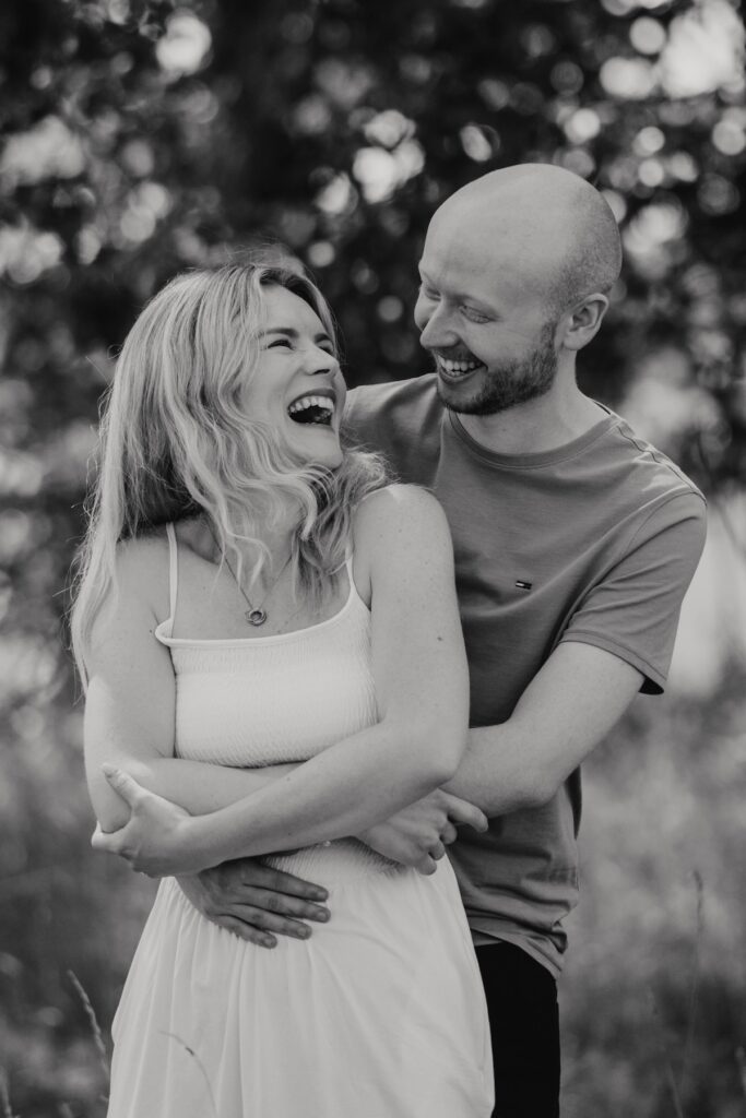 Engaged couple laughing together during a couples photography session at Snape Maltings