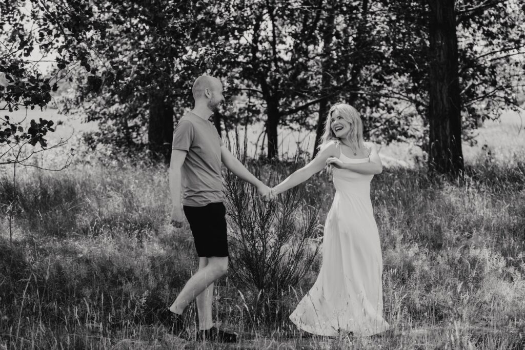 Engaged couple walking together through the Suffolk countryside near Snape Maltings