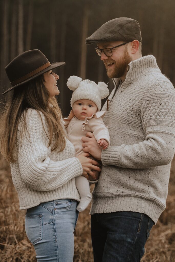 Family walking together through Thetford Forest with their little daughter