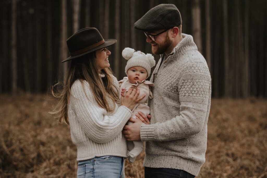 Little girl playing with her parents during a Thetford Forest family photography session