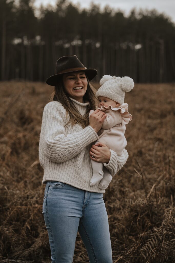 Parents playing with their daughter in the woodland at Thetford Forest