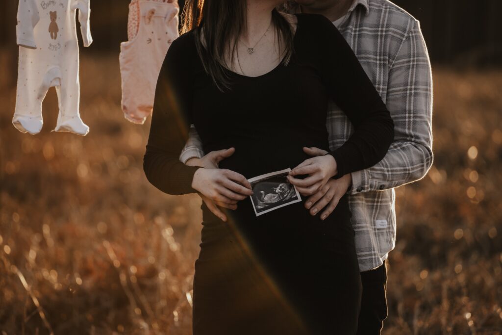 Pregnant woman smiling at her partner during their Suffolk maternity photography session