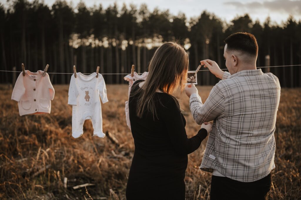 Couple laughing together during their relaxed Thetford Forest maternity photography session